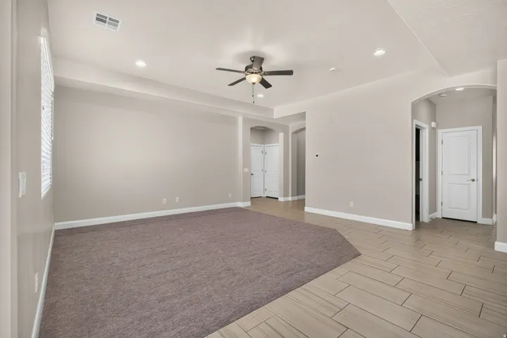 Recessed lighting, ceiling fan, arched doorways, wood-finish flooring, and neutral wall tones