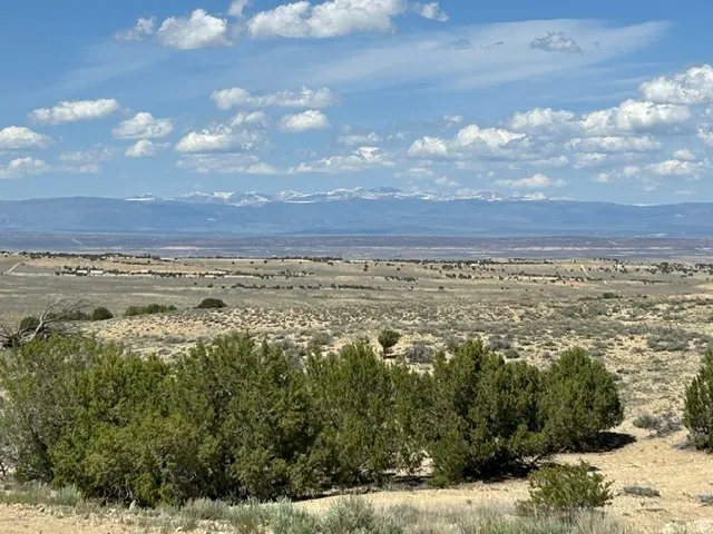 Expansive high desert landscape featuring distant mountains with snow-capped peaks