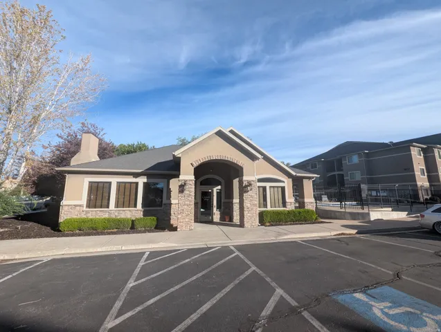 Stucco exterior with stone veneer accents, arched entry, and a pitched roof