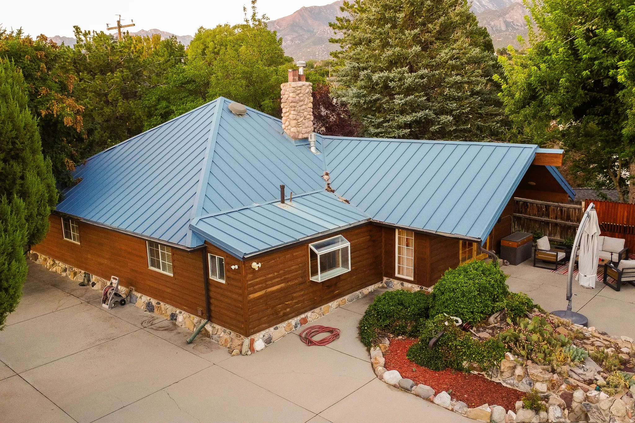 Blue metal roof with a stone chimney