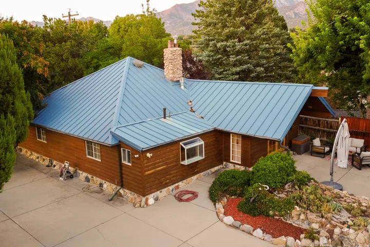 Blue metal roof with a stone chimney