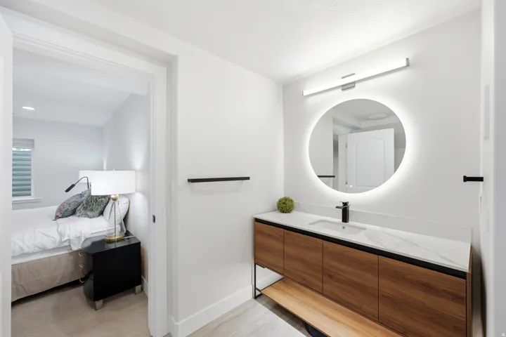 Modern vanity with wood-finish cabinetry, white countertop, and integrated rectangular sink