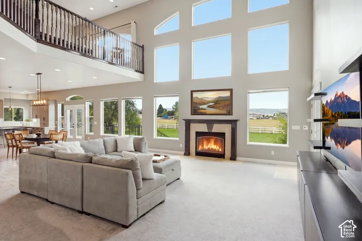 Two-story living area with multiple windows, a second-story overlook, and a fireplace with a stone surround