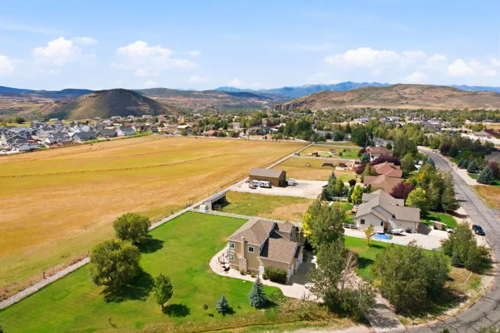 Expansive green lawn, mature trees, and a distant mountain backdrop