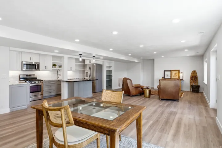 Open-concept living space with wood-finish flooring, recessed lighting, and white walls