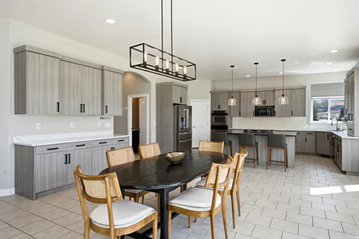 Expansive kitchen featuring light wood-finish cabinetry, stainless steel appliances, a center island with bar seating, and recessed lighting