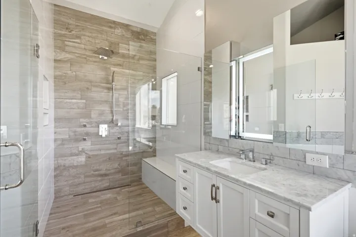 Walk-in shower with wood-finish tile, glass enclosure, and integrated bench