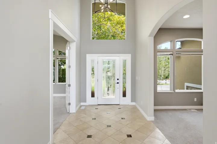 Two-story foyer with a tile floor, arched entryways, and transom windows