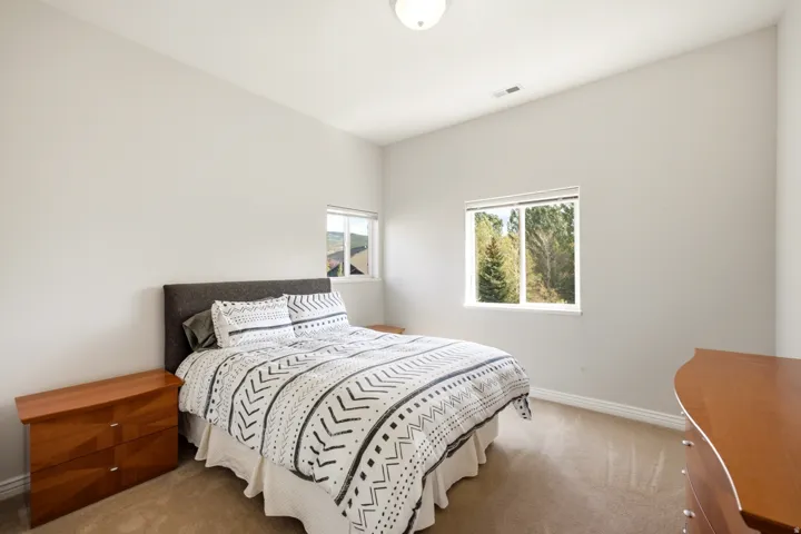 Neutral wall tones, carpeted flooring, and natural light from multiple windows