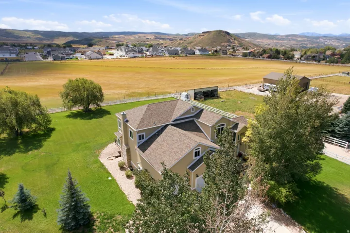 Expansive lot with manicured lawn, mature trees, and a distant mountainous backdrop