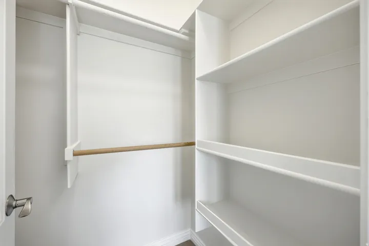 White shelving system with a wardrobe rod