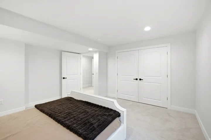 Recessed lighting illuminates neutral-toned walls and plush carpeting