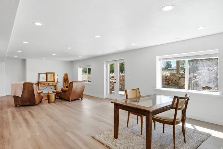 Spacious room featuring wood-finish flooring, recessed lighting, and white walls