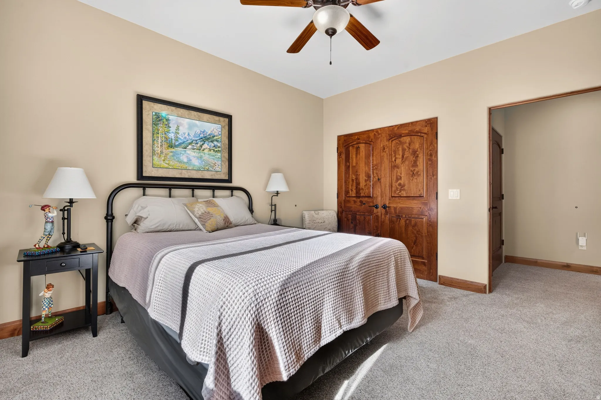 Recessed lighting, wood-finish ceiling fan, wood-finish double doors, light-colored walls, and carpeting