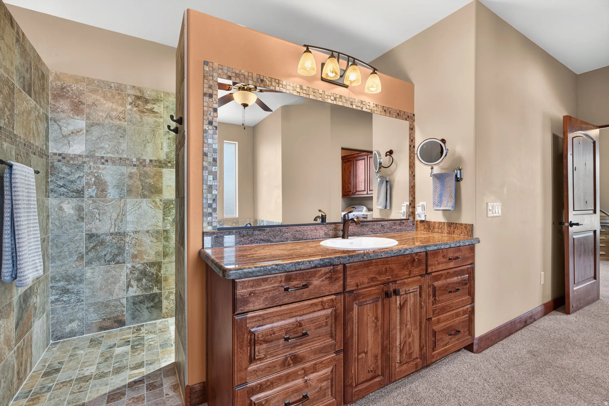 Extended vanity with an integrated sink, stone-finish countertop, and decorative mirror