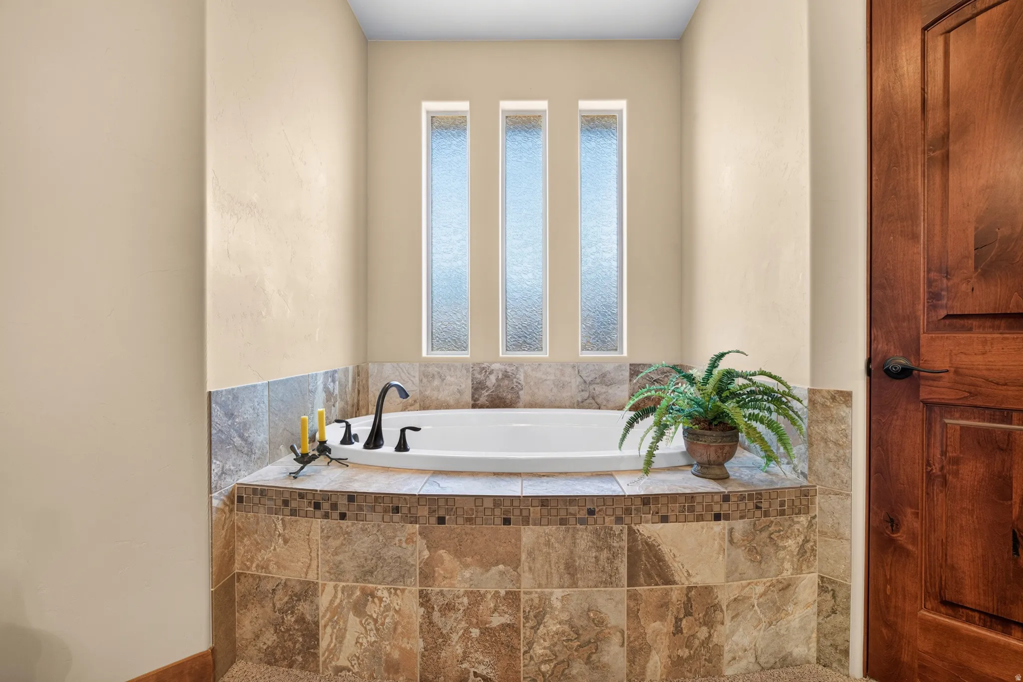 Built-in soaking tub with tile surround and mosaic accent