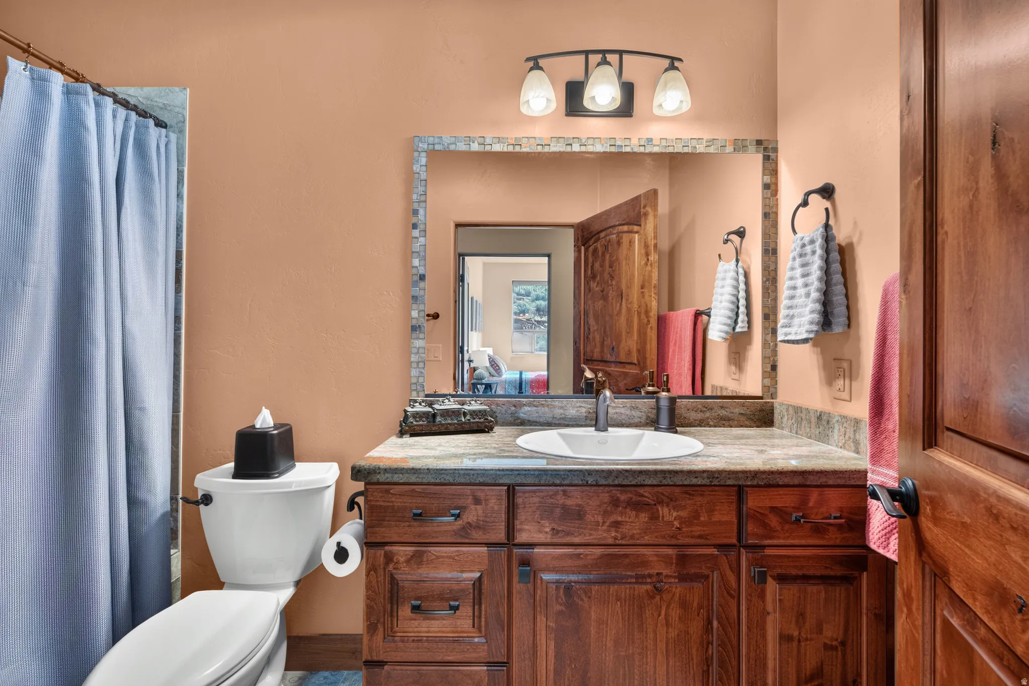 Wood-finish vanity with paneling and dark hardware