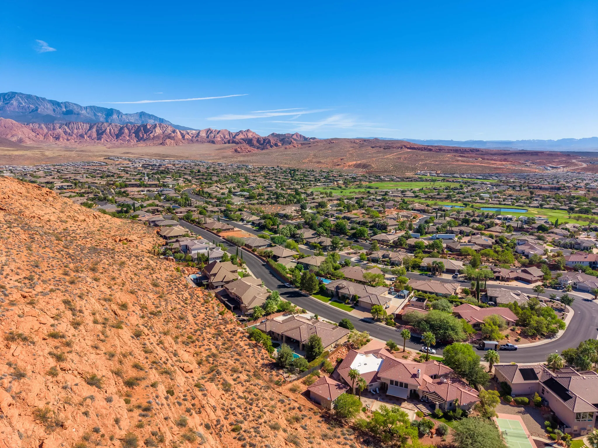 Residential neighborhood with mature landscaping and red rock mountain backdrop