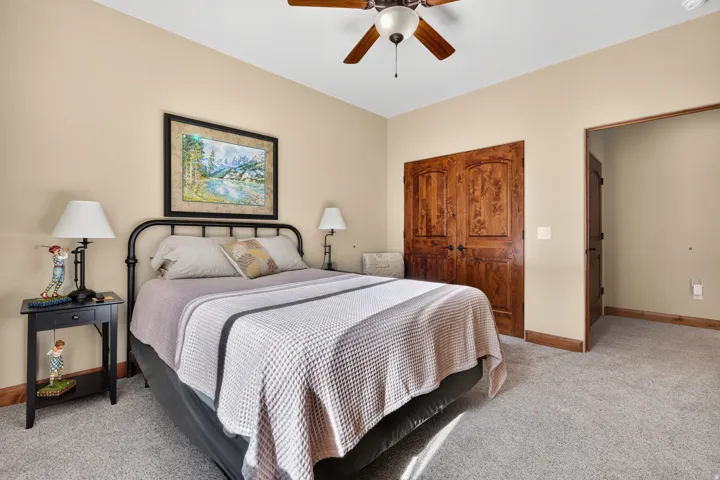 Recessed lighting, wood-finish ceiling fan, wood-finish double doors, light-colored walls, and carpeting