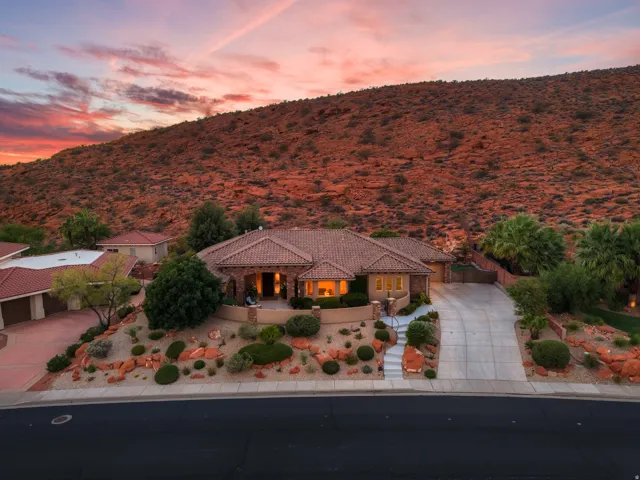 Terracotta tile roof, stucco exterior, stone accents, expansive desert landscaping, and a concrete driveway