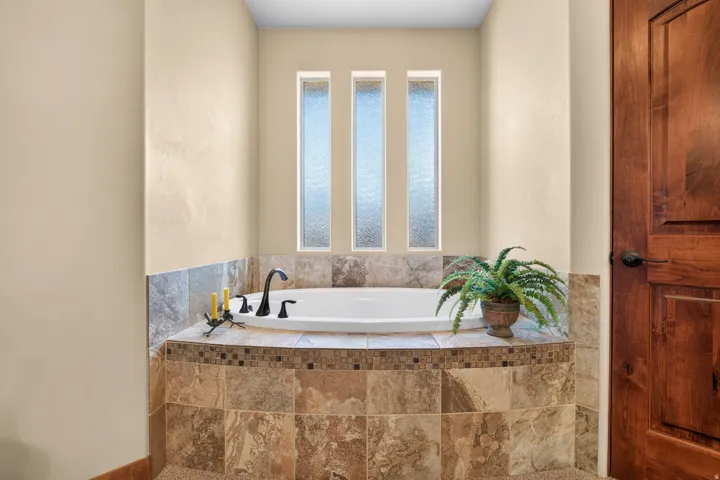 Built-in soaking tub with tile surround and mosaic accent
