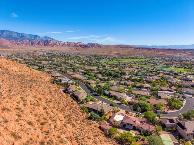 Residential neighborhood with mature landscaping and red rock mountain backdrop