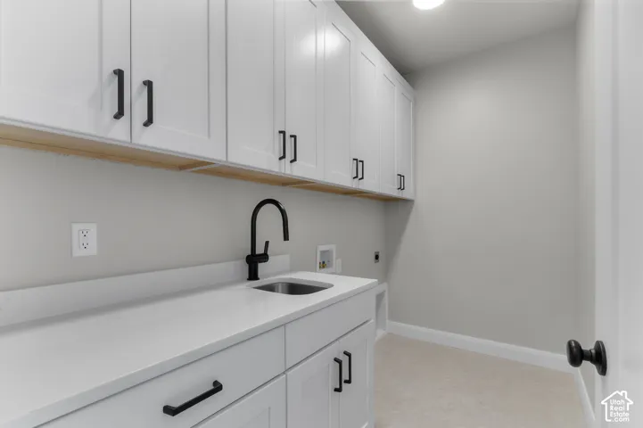 Utility room featuring white shaker-style cabinetry, quartz countertops, an undermount sink with a matte black high-arch faucet, and matching matte black hardware