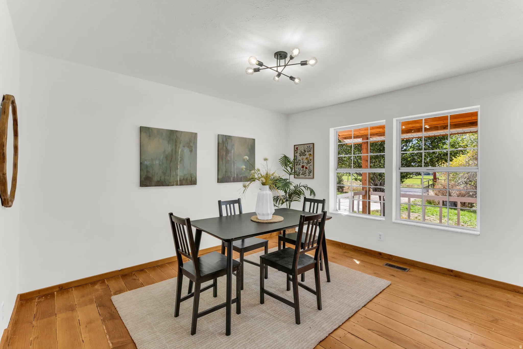 Wood-finish flooring, white walls, and a contemporary chandelier