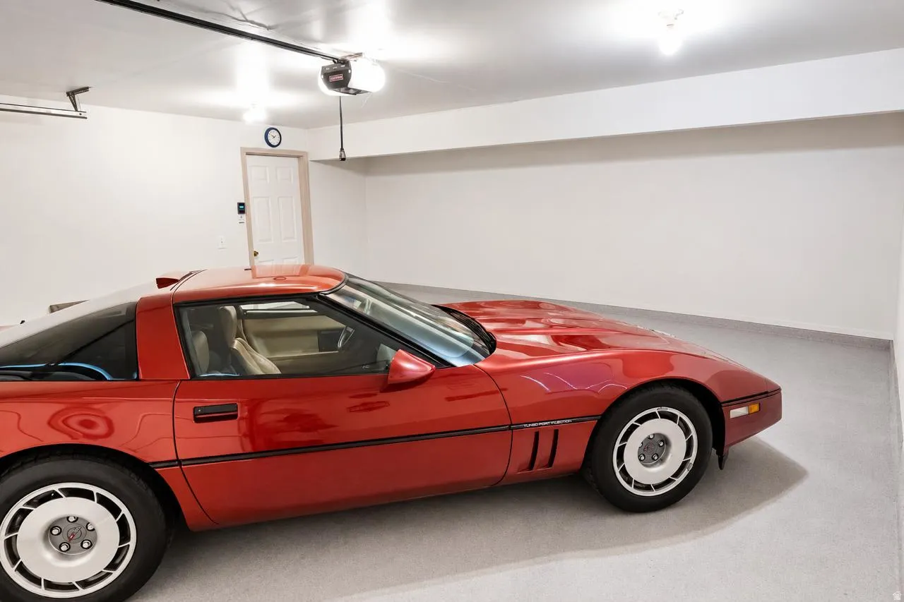 Spacious garage with light grey flooring, white walls, and bright overhead lighting