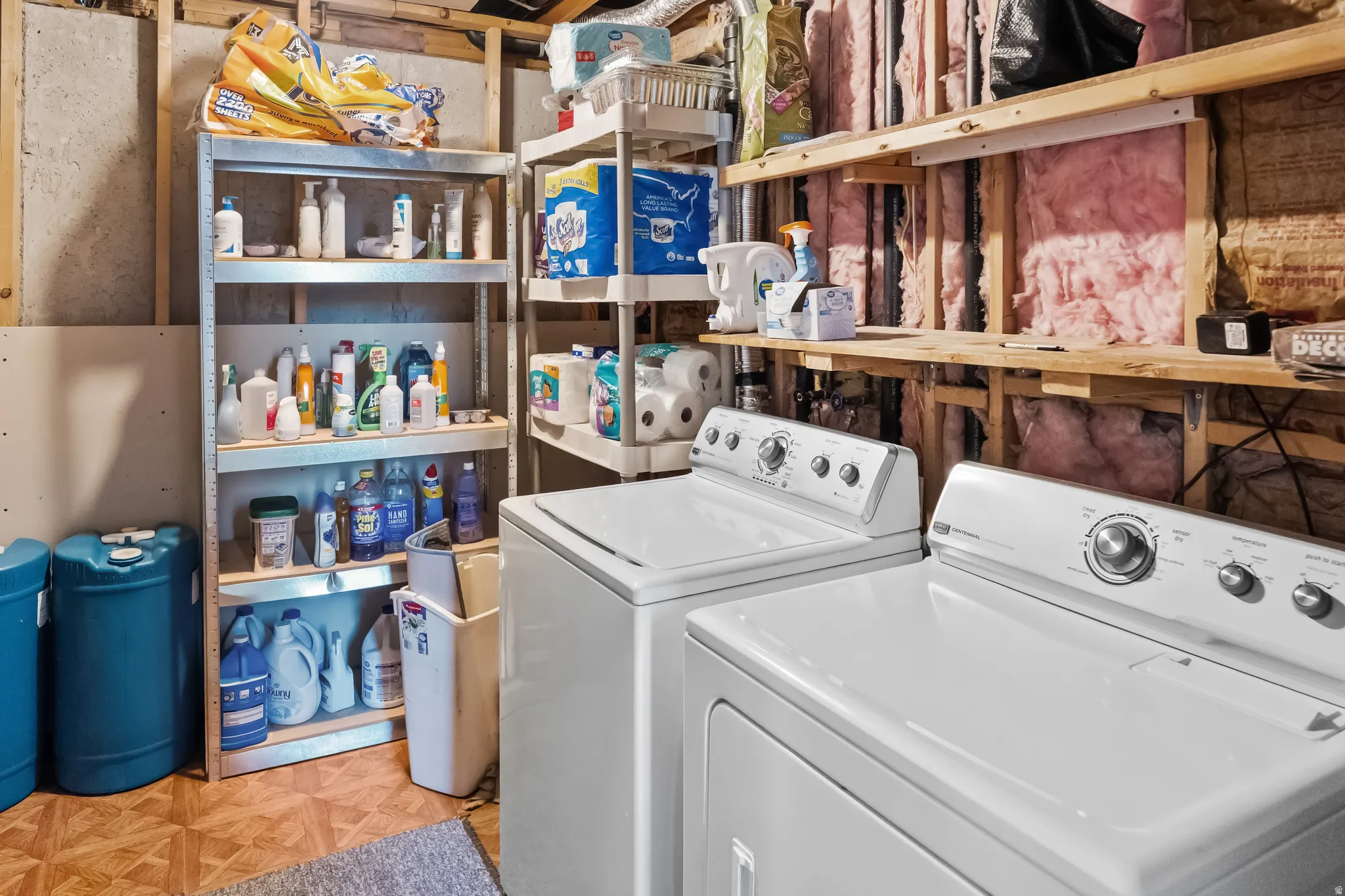 Dedicated laundry area featuring a top-load washing machine and a front-load dryer and extra storage space