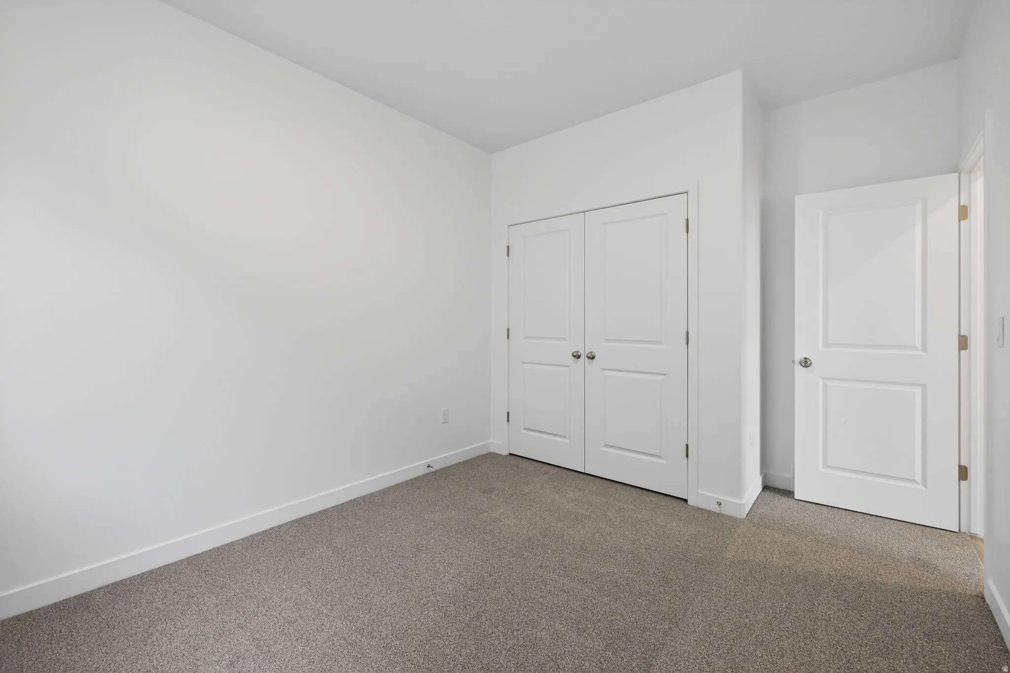 Neutral color palette with light gray carpeting, crisp white walls, and bright white trim