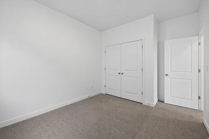 Neutral color palette with light gray carpeting, crisp white walls, and bright white trim