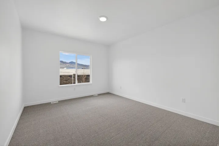 Recessed ceiling light, white walls, gray carpet, window with exterior scenery