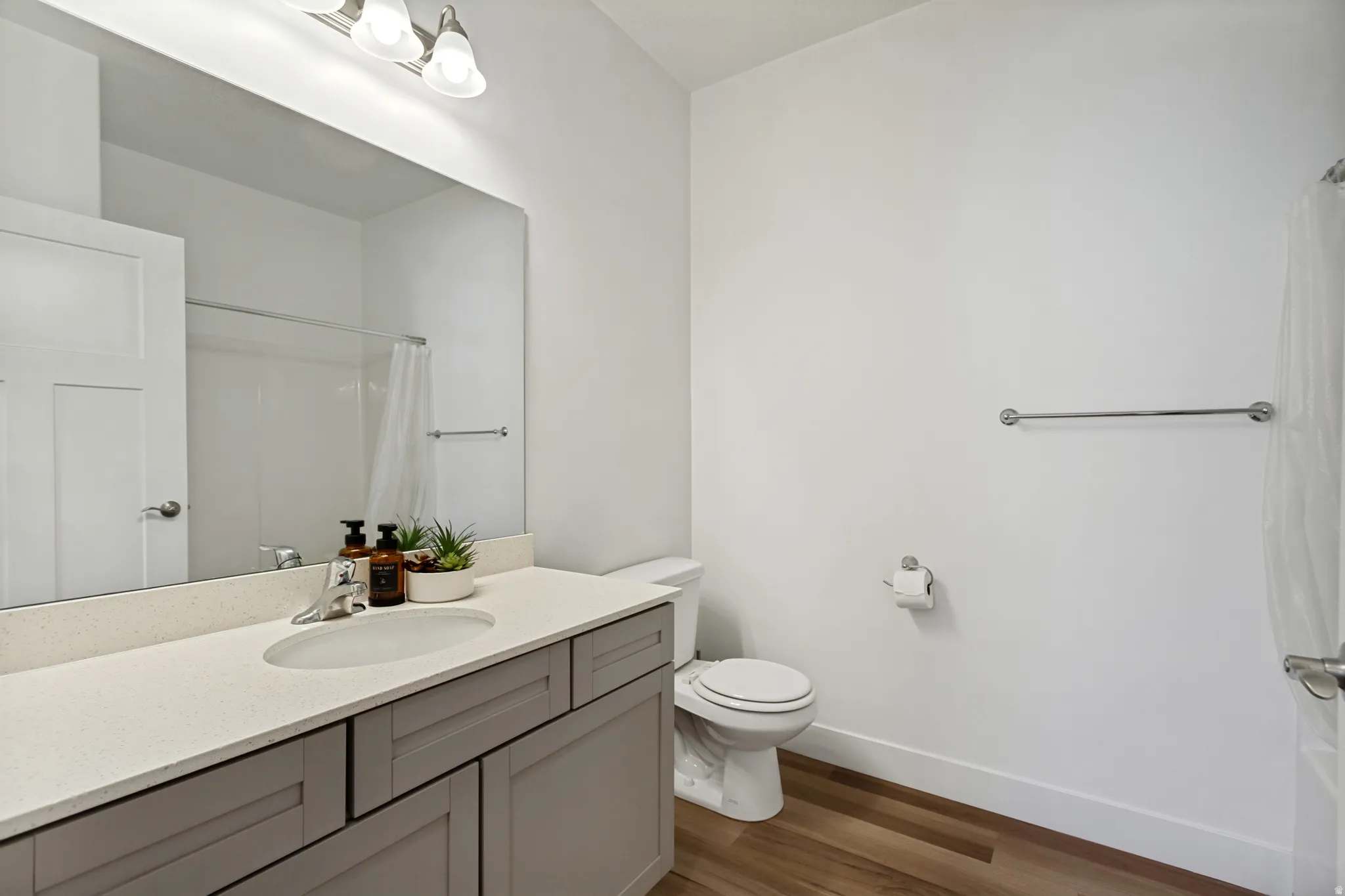 Hall bath with quartz countertop, undermount sink, and LVP flooring