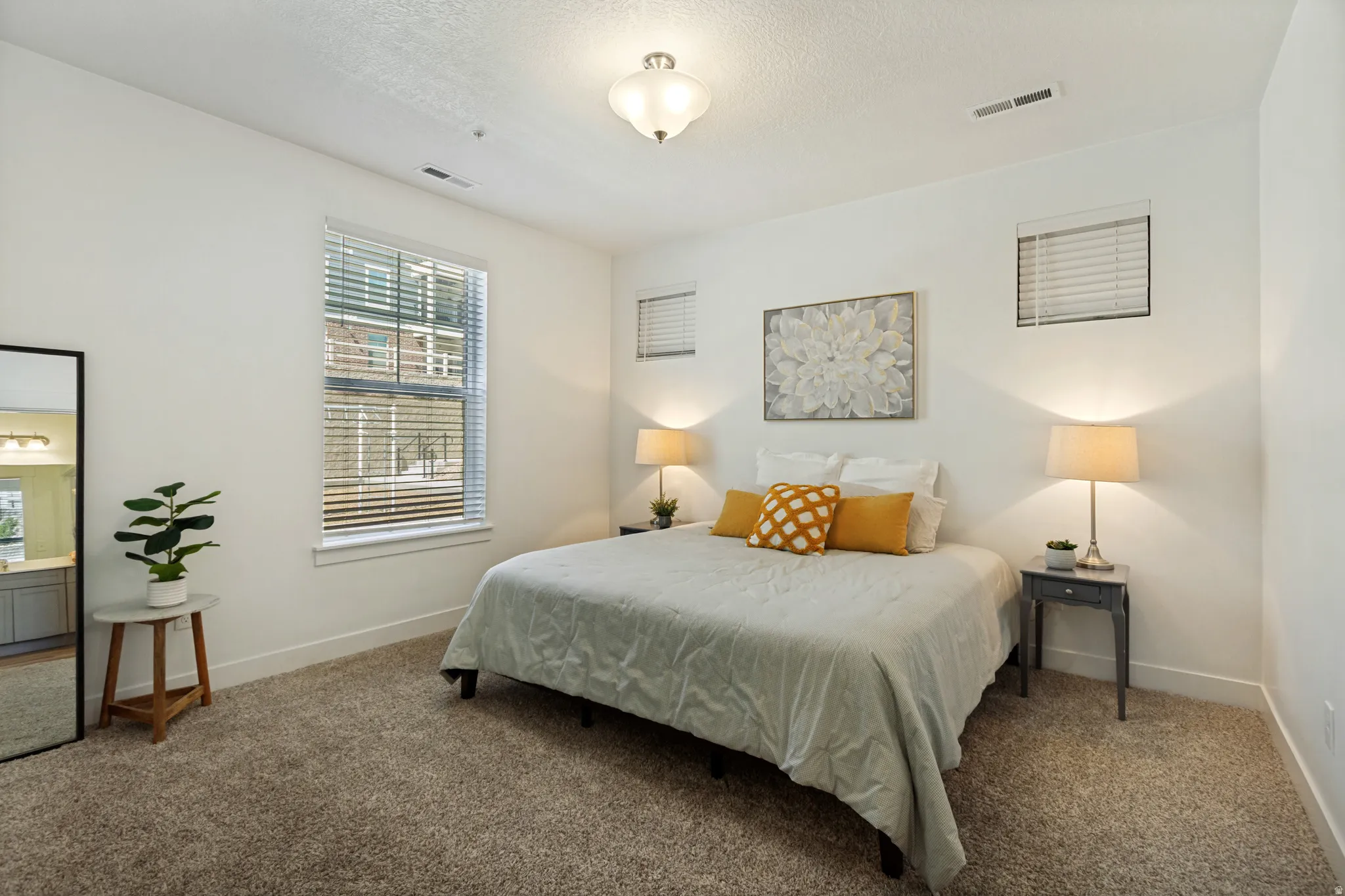 The generous primary bedroom features a tall ceiling, plenty of light