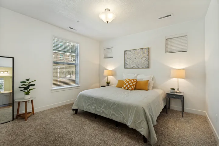 The generous primary bedroom features a tall ceiling, plenty of light