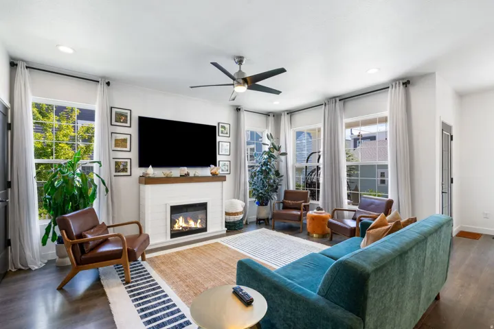 Fireplace with a wood mantle, wood-finish flooring, recessed lighting, and a ceiling fan