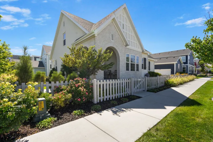 Brick exterior with arched entry, gabled roof, and white picket fencing