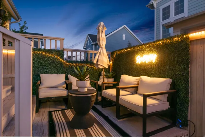 Outdoor deck featuring wood-finish flooring, a decorative privacy wall, and built-in lighting