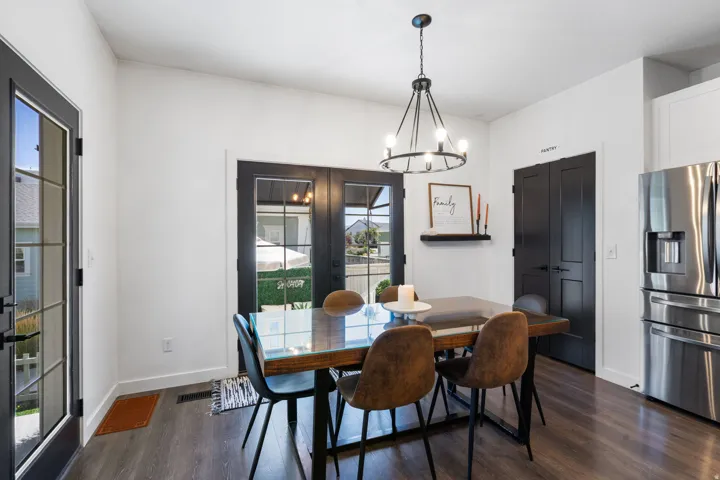 White walls with dark trim, wood-finish flooring, and a contemporary chandelier