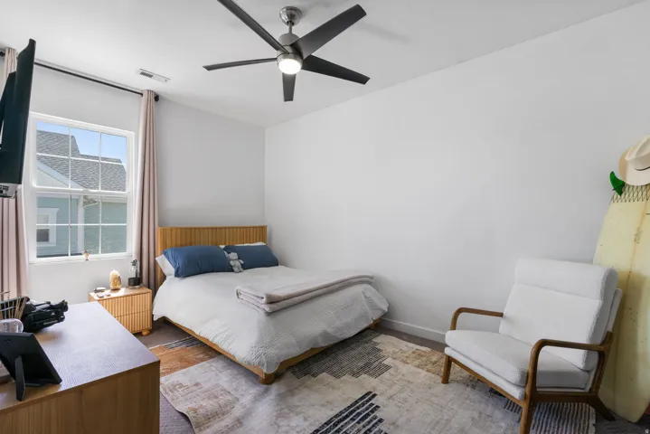 Ceiling fan with integrated lighting, wood-finish flooring, and a double-hung window