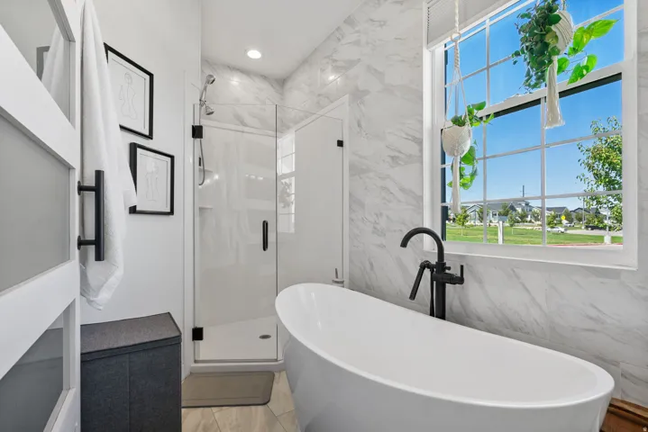 Freestanding soaking tub with a floor-mounted matte black faucet