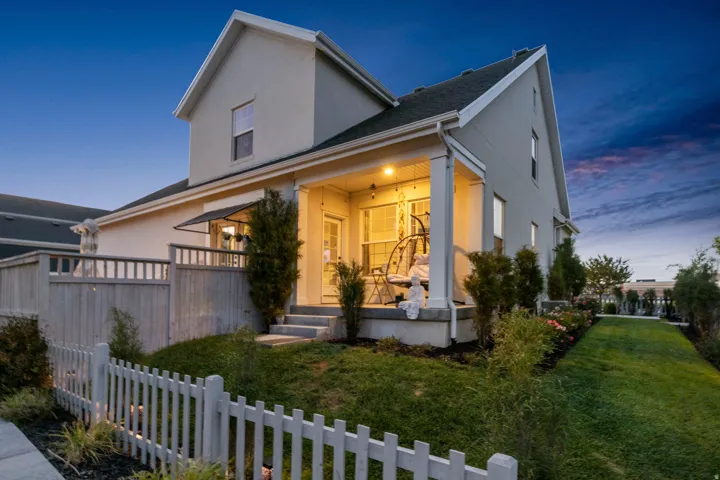 Covered porch with column supports, exterior lighting, and an awning over the entry