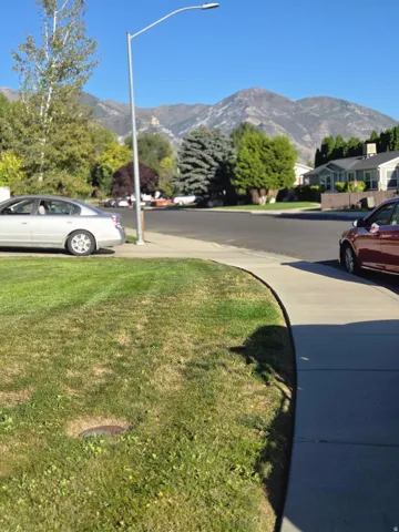 Manicured lawn with concrete sidewalk and mountain backdrop