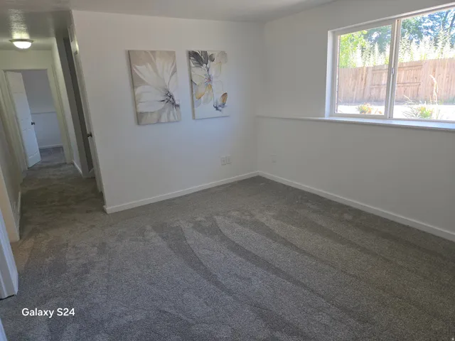 New carpeting, white wall paint, and a bright window