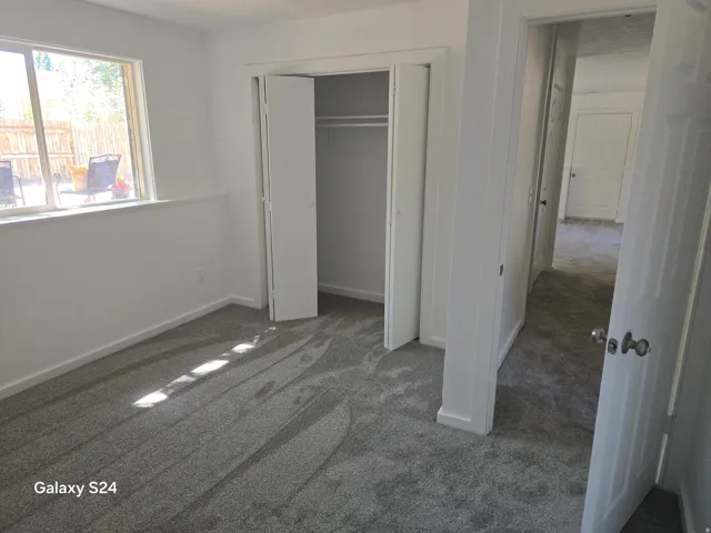 Plush carpeting, bright white walls, and a window with a deep sill