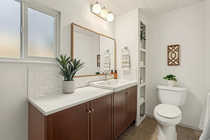 Primary Bathroom. Integrated vanity with a single basin, wood-finish cabinetry, and a white countertop