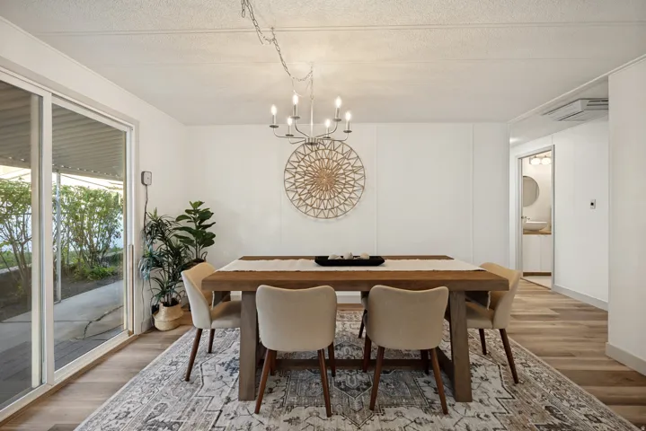 Sliding glass door leading to exterior, wood-finish flooring, recessed lighting, and a modern chandelier