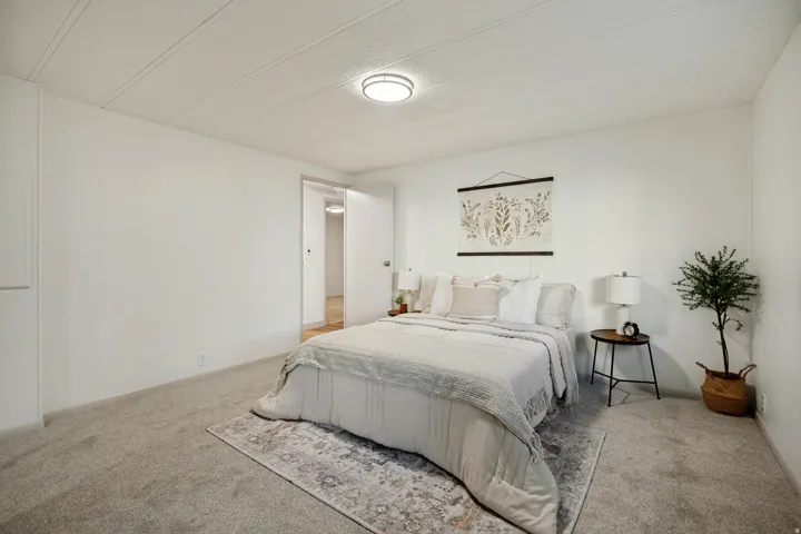 Primary Bedroom with carpeted flooring, white walls, flush mount ceiling light, and a solid interior door