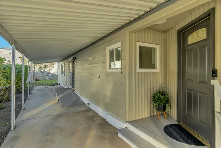 Covered walkway featuring a concrete patio and ramp into kitchen/dining area.